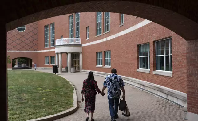 Matt Dzik, right, drops his wife, Lesley, off at work at the engineering library at the University of Illinois in Urbana, Ill., Sunday, Sept. 22, 2024. (AP Photo/David Goldman)