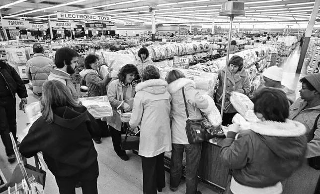 FILE - Kmart shoppers mill around the flashing blue light, sign of the "Blue Light Special," at the first Kmart ever built in Garden City, Mich., on March 1, 1982. (AP Photo/Dale Young, File)