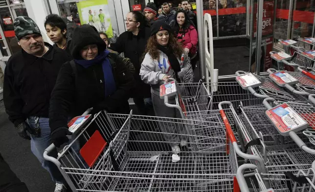 FILE - Shoppers rush into a Kmart store in Chicago on on Nov. 25, 2011 for Black Friday sale. (AP Photo/Nam Y. Huh, File)