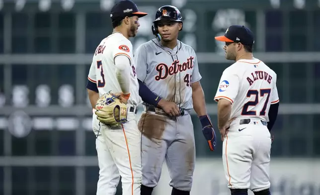 Detroit Tigers' Wenceel Pérez, center, talks with Houston Astros shortstop Jeremy Peña (3) and second baseman Jose Altuve (27) during a video review during the seventh inning of Game 1 of an AL Wild Card Series baseball game, Tuesday, Oct. 1, 2024, in Houston. (AP Photo/Kevin M. Cox)