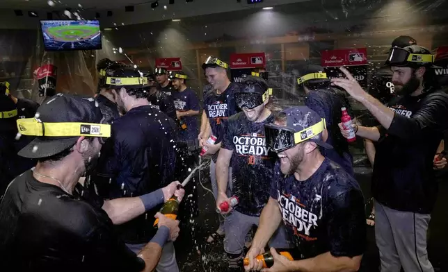 The Detroit Tigers celebrate in the clubhouse after defeating the Houston Astros in Game 2 to clinch the AL Wild Card baseball series, Wednesday, Oct. 2, 2024, in Houston. (AP Photo/Kevin M. Cox)