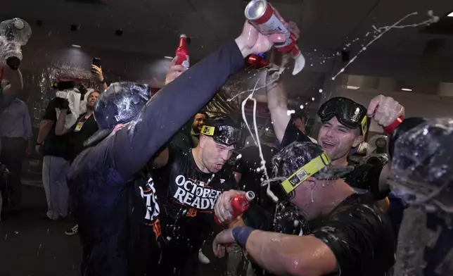 The Detroit Tigers celebrate in the clubhouse after defeating the Houston Astros in Game 2 to clinch the AL Wild Card baseball series, Wednesday, Oct. 2, 2024, in Houston. (AP Photo/Kevin M. Cox)