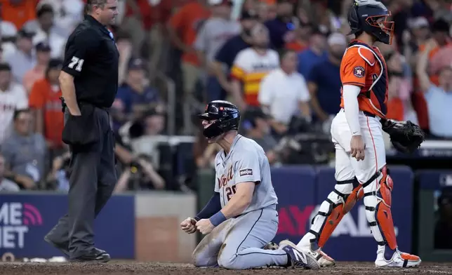 Detroit Tigers' Spencer Torkelson, center, celebrates in front of umpire Jordan Baker, left, and Houston Astros catcher Yainer Diaz, right, after Torkelson scored on a bases-clearing double by Andy Ibanez in the eighth inning of Game 2 of an AL Wild Card Series baseball game Wednesday, Oct. 2, 2024, in Houston. (AP Photo/Kevin M. Cox)