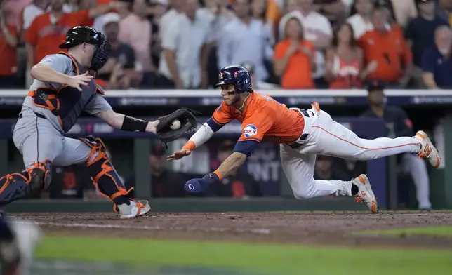 Detroit Tigers catcher Jake Rogers reaches out for the throw to the plate as Houston Astros' Jeremy Pena, right, scores on a Jose Altuve sacrifice fly in the seventh inning of Game 2 of an AL Wild Card Series baseball game Wednesday, Oct. 2, 2024, in Houston. (AP Photo/Kevin M. Cox)