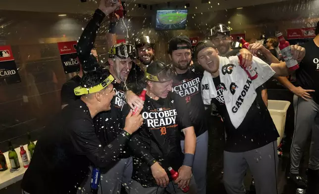 The Detroit Tigers celebrate in the clubhouse after defeating the Houston Astros in Game 2 to clinch the AL Wild Card baseball series, Wednesday, Oct. 2, 2024, in Houston. (AP Photo/Kevin M. Cox)