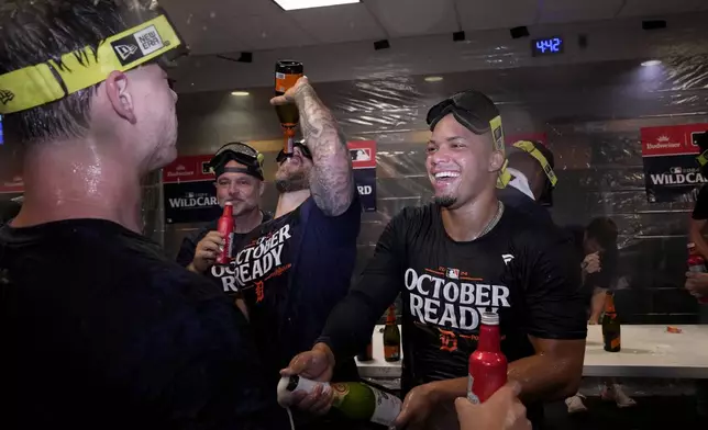 Detroit Tigers' Wenceel Perez, right, celebrates with the team in the clubhouse after defeating the Houston Astros in Game 2 to clinch the AL Wild Card baseball series, Wednesday, Oct. 2, 2024, in Houston. (AP Photo/Kevin M. Cox)