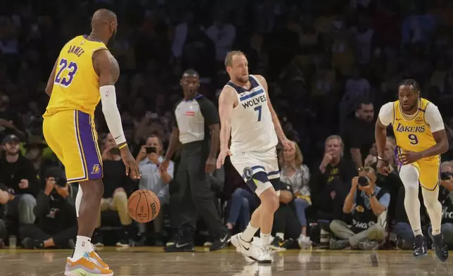 Los Angeles Lakers forward LeBron James (23) looks to pass to guard Bronny James (9) during the first half of an NBA basketball game against the Minnesota Timberwolves, Tuesday, Oct. 22, 2024, in Los Angeles. (AP Photo/Eric Thayer)