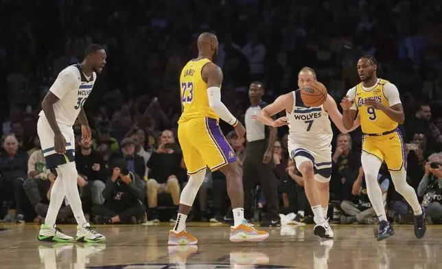 Los Angeles Lakers forward LeBron James (23) passes to guard Bronny James (9) during the first half of an NBA basketball game against the Minnesota Timberwolves, Tuesday, Oct. 22, 2024, in Los Angeles. (AP Photo/Eric Thayer)