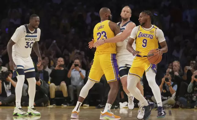 Los Angeles Lakers guard Bronny James (9) handles the ball during the first half of an NBA basketball game against the Minnesota Timberwolves, Tuesday, Oct. 22, 2024, in Los Angeles. (AP Photo/Eric Thayer)