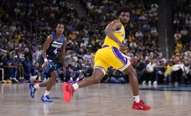 Los Angeles Lakers guard Bronny James, right, runs to the other end of the court as Minnesota Timberwolves guard Rob Dillingham watches during the first half of a preseason NBA basketball game, Friday, Oct. 4, 2024, in Palm Desert, Calif. (AP Photo/Mark J. Terrill)