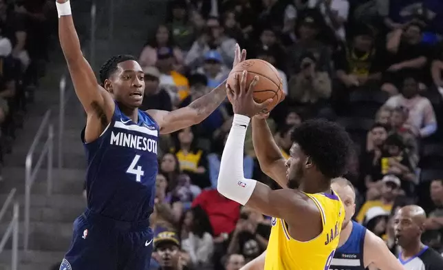 Los Angeles Lakers guard Bronny James, right, tries to shoot as Minnesota Timberwolves guard Rob Dillingham defends during the first half of a preseason NBA basketball game, Friday, Oct. 4, 2024, in Palm Desert, Calif. (AP Photo/Mark J. Terrill)