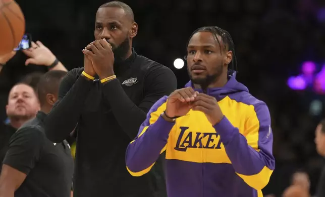 Los Angeles Lakers forward LeBron James, left, and guard Bronny James warm up before an NBA basketball game against the Minnesota Timberwolves, Tuesday, Oct. 22, 2024, in Los Angeles. (AP Photo/Eric Thayer)