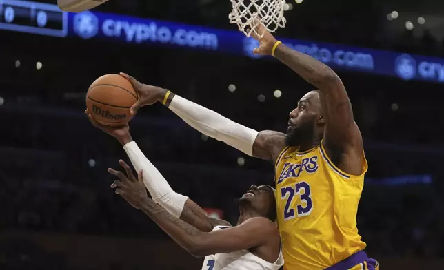 Los Angeles Lakers forward LeBron James (23) blocks a shot attempt by Minnesota Timberwolves forward Jaden McDaniels (3) during the first half of an NBA basketball game, Tuesday, Oct. 22, 2024, in Los Angeles. (AP Photo/Eric Thayer)