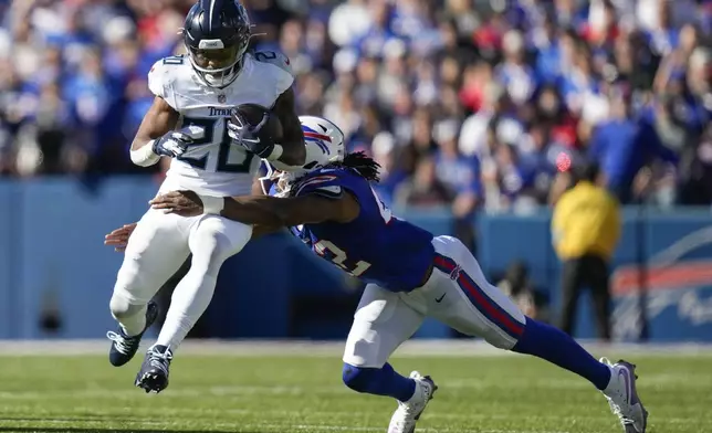 Tennessee Titans running back Tony Pollard (20) runs the ball against the Buffalo Bills linebacker Dorian Williams (42) during the first half of an NFL football game Sunday, Oct. 20, 2024, in Orchard Park, N.Y. (AP Photo/Charles Krupa)