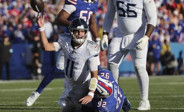 Tennessee Titans quarterback Mason Rudolph (11) is tackled by Buffalo Bills defensive tackle DaQuan Jones (92) as he throws the ball during the second half of an NFL football game Sunday, Oct. 20, 2024, in Orchard Park, N.Y. (AP Photo/Jeffrey T. Barnes)