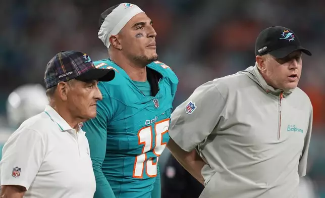 Miami Dolphins linebacker Jaelan Phillips (15) is assisted off the field during the second half of an NFL football game against the Tennessee Titans, Monday, Sept. 30, 2024, in Miami Gardens, Fla. (AP Photo/Rebecca Blackwell)