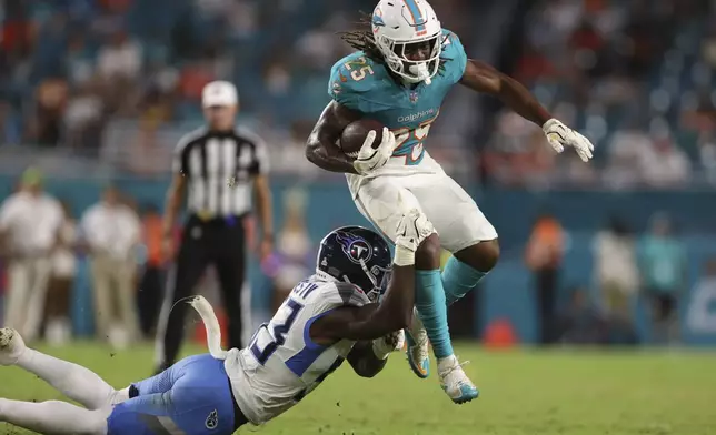 Tennessee Titans linebacker Ernest Jones IV (53) grabs Miami Dolphins running back Jaylen Wright (25) during the second half of an NFL football game, Monday, Sept. 30, 2024, in Miami Gardens, Fla. (AP Photo/Brennan Asplen)