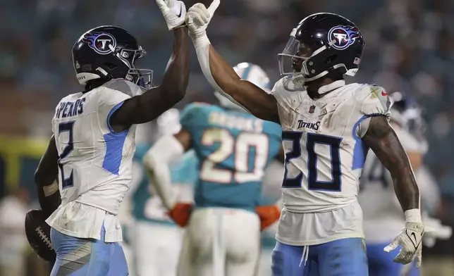 Tennessee Titans running back Tyjae Spears (2) celebrates his touchdown with running back Tony Pollard (20) during the second half of an NFL football game against the Miami Dolphins, Monday, Sept. 30, 2024, in Miami Gardens, Fla. (AP Photo/Brennan Asplen)