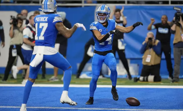 Detroit Lions wide receiver Amon-Ra St. Brown (14) celebrates his touchdown with teammate Tim Patrick (17) during the first half of an NFL football game against the Tennessee Titans, Sunday, Oct. 27, 2024, in Detroit. (AP Photo/Paul Sancya)