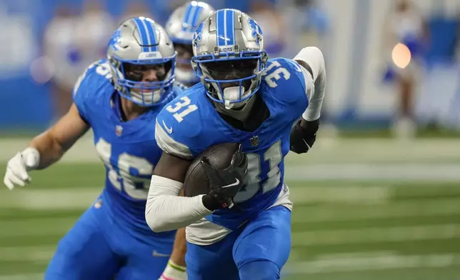 Detroit Lions safety Kerby Joseph (31) runs with the ball after making an interception during the first half of an NFL football game against the Tennessee Titans, Sunday, Oct. 27, 2024, in Detroit. (AP Photo/Paul Sancya)