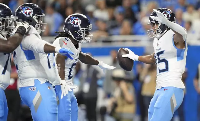 Tennessee Titans wide receiver Nick Westbrook-Ikhine, right, celebrates a touchdown with teammates during the first half of an NFL football game against the Detroit Lions, Sunday, Oct. 27, 2024, in Detroit. (AP Photo/Carlos Osorio)