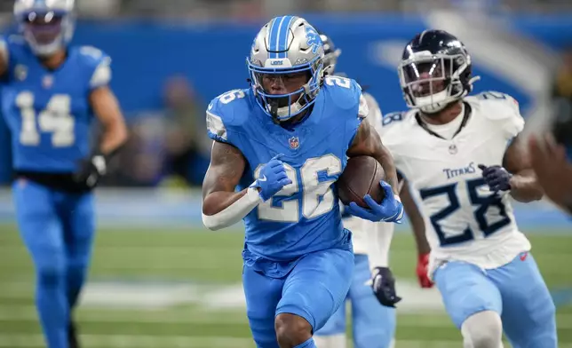 Detroit Lions running back Jahmyr Gibbs (26) runs for a touchdown past Tennessee Titans safety Quandre Diggs (28) during the first half of an NFL football game Sunday, Oct. 27, 2024, in Detroit. (AP Photo/Paul Sancya)