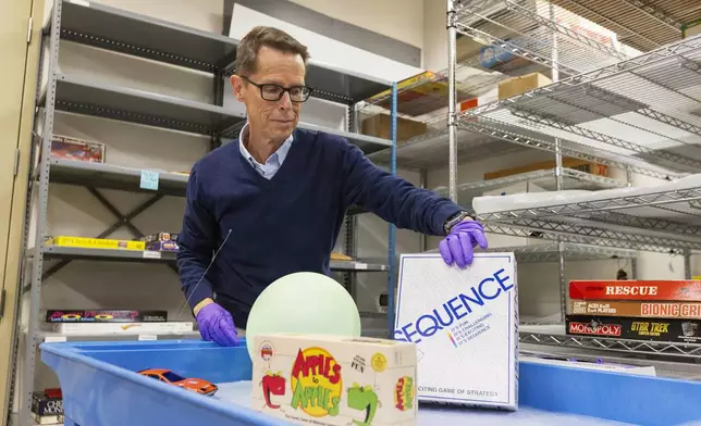 Christopher Bensch, chief curator at The Strong National Museum of Play, takes out toys and games that are finalists for the 2024 Hall of Fame, Tuesday, Oct. 15, 2024, in Rochester, N.Y. (AP Photo/Lauren Petracca)