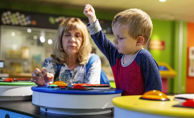 Rita Wilks plays a game of Bingo with her grandson, Oliver, 2, while visiting The Strong National Museum of Play, Tuesday, Oct. 15, 2024, in Rochester, N.Y. (AP Photo/Lauren Petracca)