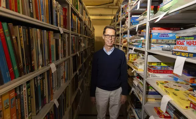 Christopher Bensch, chief curator at The Strong National Museum of Play, stands among shelves of toys and games in a storage area below the museum, Tuesday, Oct. 15, 2024, in Rochester, N.Y. (AP Photo/Lauren Petracca)