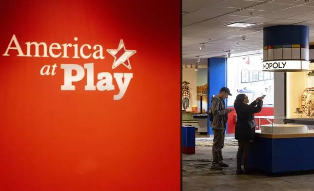 A visitor takes a picture of an original Monopoly set on display at The Strong National Museum of Play, Tuesday, Oct. 15, 2024, in Rochester, N.Y. (AP Photo/Lauren Petracca)