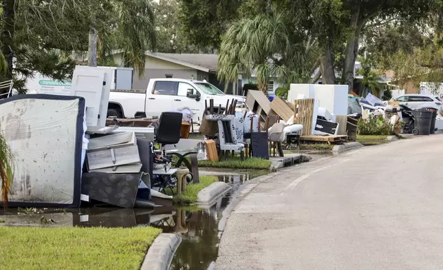 Residents discard items from their homes which filled with floodwaters from Hurricane Helene in the Shore Acres neighborhood on Saturday, Sept. 28, 2024, in St. Petersburg, Fla. (AP Photo/Mike Carlson)