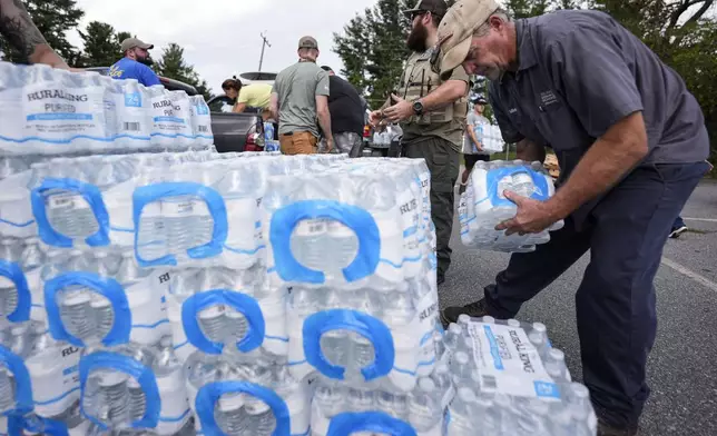 Volunteers stage water for people in the aftermath of Hurricane Helene, Monday, Sept. 30, 2024, in Asheville, N.C. (AP Photo/Mike Stewart)