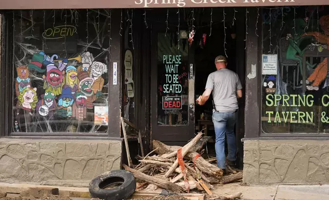 A person enters a heavily damaged building as clean up in the aftermath of Hurricane Helene begins Tuesday, Oct. 1, 2024, in Hot Springs, N.C. (AP Photo/Jeff Roberson)