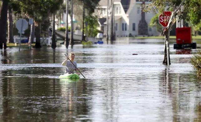 FILE - Halle Brooks kayaks down a street flooded by Hurricane Helene in the Shore Acres neighborhood Sept. 27, 2024, in St. Petersburg, Fla. (AP Photo/Mike Carlson, File)