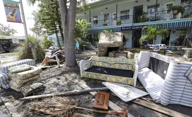 Contents of rooms are emptied on the street after flooding from Hurricane Helene on Friday, Sept. 27, 2024, in Gulfport, Fla. (AP Photo/Mike Carlson)