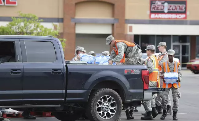 Members of the Civil Air Patrol load water for Hurricane Helene relief into a pickup truck at a water station in Augusta, Ga., on Tuesday, Oct. 1, 2024. (AP Photo/Jeffrey Collins)