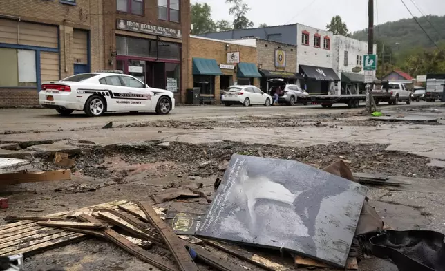 A Madison County sheriff's vehicle passes damaged buildings along Bridge Street in the aftermath of Hurricane Helene Tuesday, Oct. 1, 2024, in Hot Springs, N.C. (AP Photo/Jeff Roberson)