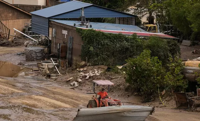 A worker moves debris in the aftermath of Hurricane Helene, Monday, Sept. 30, 2024, in Asheville, N.C. (AP Photo/Mike Stewart)