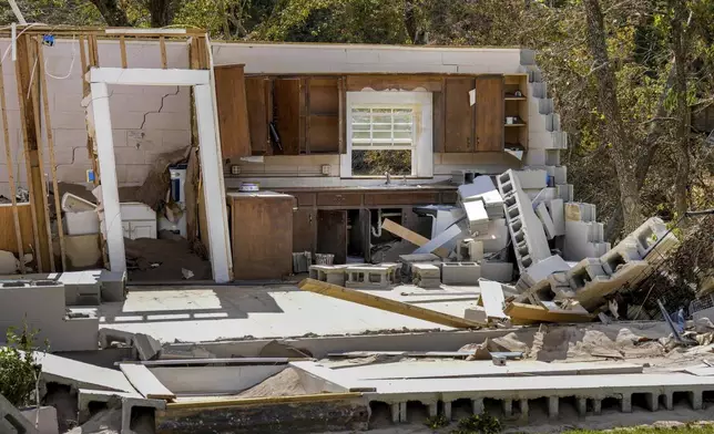 Damaged to one of the White family's homes that was destroyed by Hurricane Helene is seen, Tuesday, Oct. 1, 2024 in Morganton, N.C. The adjacent Catawba River flooded due to torrential rains destroying seven of the family's nine homes on the property. (AP Photo/Kathy Kmonicek)