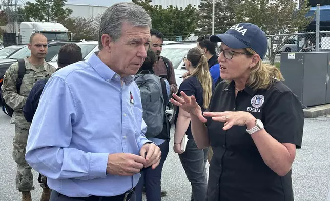 North Carolina Gov. Roy Cooper speaks with FEMA Administrator Deanne Criswell on Monday, Sept. 30, at the Asheville Regional Airport in Fletcher, N.C. (AP Photo/Gary Robertson)