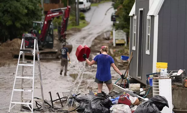 People clean up in the aftermath of Hurricane Helene Tuesday, Oct. 1, 2024, in Hot Springs, N.C. (AP Photo/Jeff Roberson)