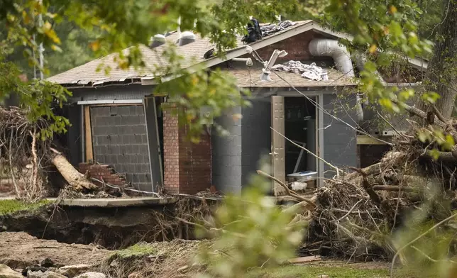 A building is damaged as water rushed over the roof in the aftermath of Hurricane Helene, Tuesday, Oct. 1, 2024, in Swannanoa, N.C. (AP Photo/Mike Stewart)