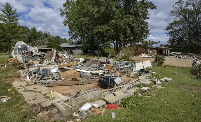 All that is left is the foundation of one of the White family homes, destroyed by Hurricane Helene, Tuesday, Oct. 1, 2024 in Morganton, N.C. The adjacent Catawba River flooded due to torrential rains destroying seven of the family's nine homes on the property. (AP Photo/Kathy Kmonicek)