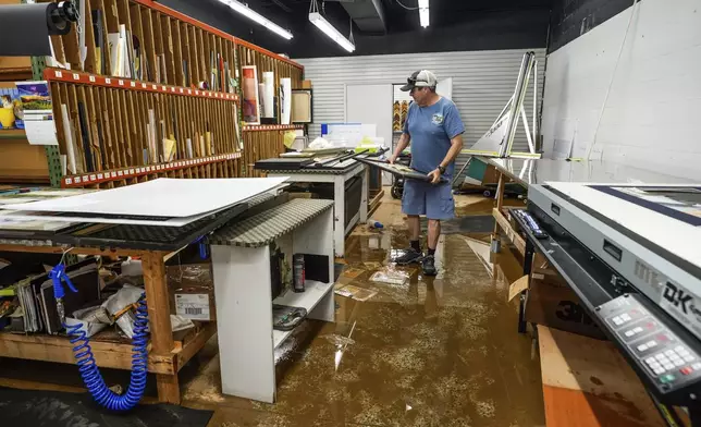 Jason Whisnant, General Manager at International Moulding checks frames for damage from flooding due to Hurricane Helene in the production room of his store, a frame shop on North Green Street, Monday, Sept. 30, 2024, in Morganton, N.C. (AP Photo/Kathy Kmonicek)