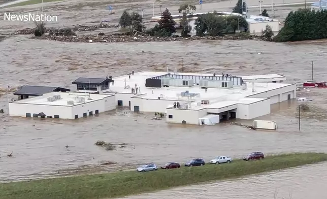 In this image made from a video provided by NewsNation, people can be seen on the roof of the Unicoi County Hospital in Erwin, Tenn., on Friday, Sept. 27, 2024. (NewsNation via AP)