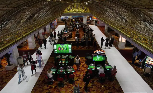 FILE - People walk through the casino floor at the Tropicana hotel-casino Friday, March 29, 2024, in Las Vegas. (AP Photo/John Locher, File)