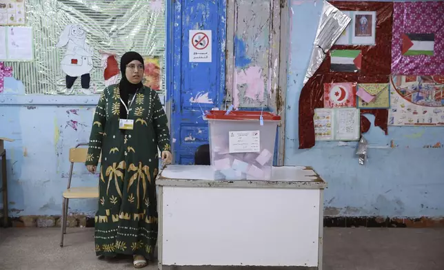 An election official stands next to a ballot box ahead of the vote counting after the presidential elections in the capital Tunis, Tunisia, Sunday, Oct. 6, 2024. (AP Photo/Anis Mili)