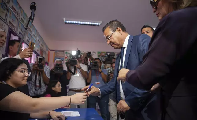 Tunisian President Presidential candidate Zouhair Maghzaoui prepares to cast his vote at a polling station during the presidential elections, in the capital Tunis, Tunisia, Sunday, Oct. 6, 2024. (AP Photo/Ons Abid)