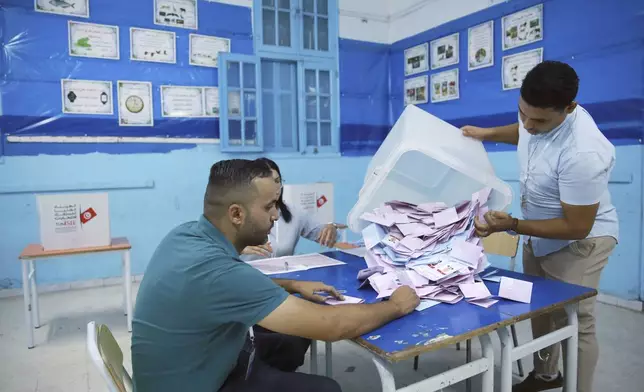 Election officials open a ballot box to count votes after the presidential elections, in the capital Tunis, Tunisia, Sunday, Oct. 6, 2024. (AP Photo/Anis Mili)