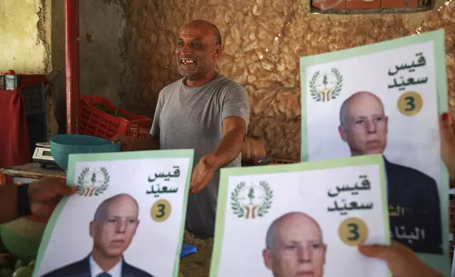 Supporters of Tunisian President and candidate for re-election Kais Saied meet with residents of a neighbourhood during a campaign tour, in Ariana, Tunisia, Thursday, Sept. 26, 2024. (AP Photo/Anis Mili)